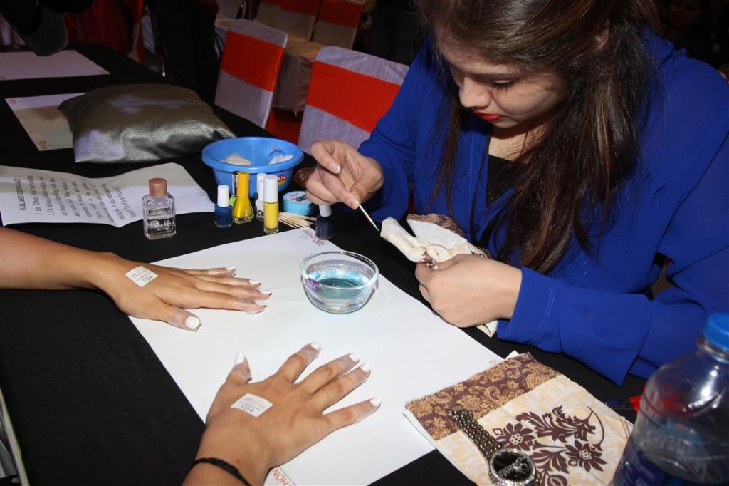 Contestant performing nail art on a model