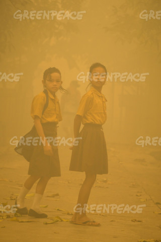 Marnie and Sarah, two young girl preparing to go to school under a heavy of haze from forest fires at Sei Ahass village in the district of Kapuas in the Central Kalimantan province on Borneo island, Indonesia, Friday Saturday 24 October 2015. Photo Ardiles Rante / Hati Kecil Visuals for Greenpeace
