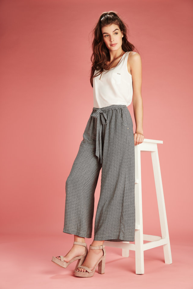 Featuring new categories for women by Being Human. Wearing sleeveless white top paired with printed srawstring culottes