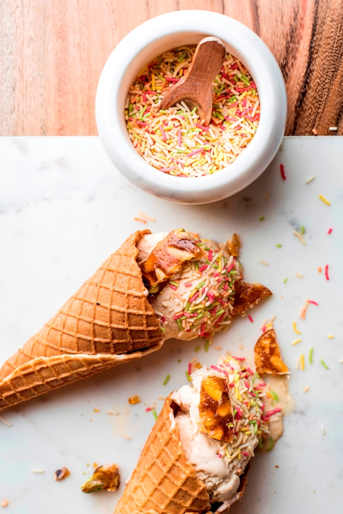 Ice cream on waffle cone with nougatine and sprinkles