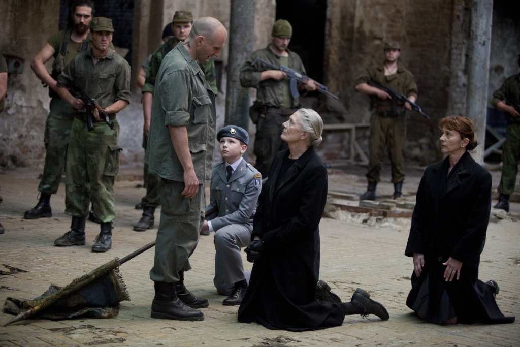 (Centre Group) Young Martius (Harry Fenn) and Volumnia (Vanessa Redgrave) kneel before Coriolanus (Ralph Fiennes) to plead the case of Rome.