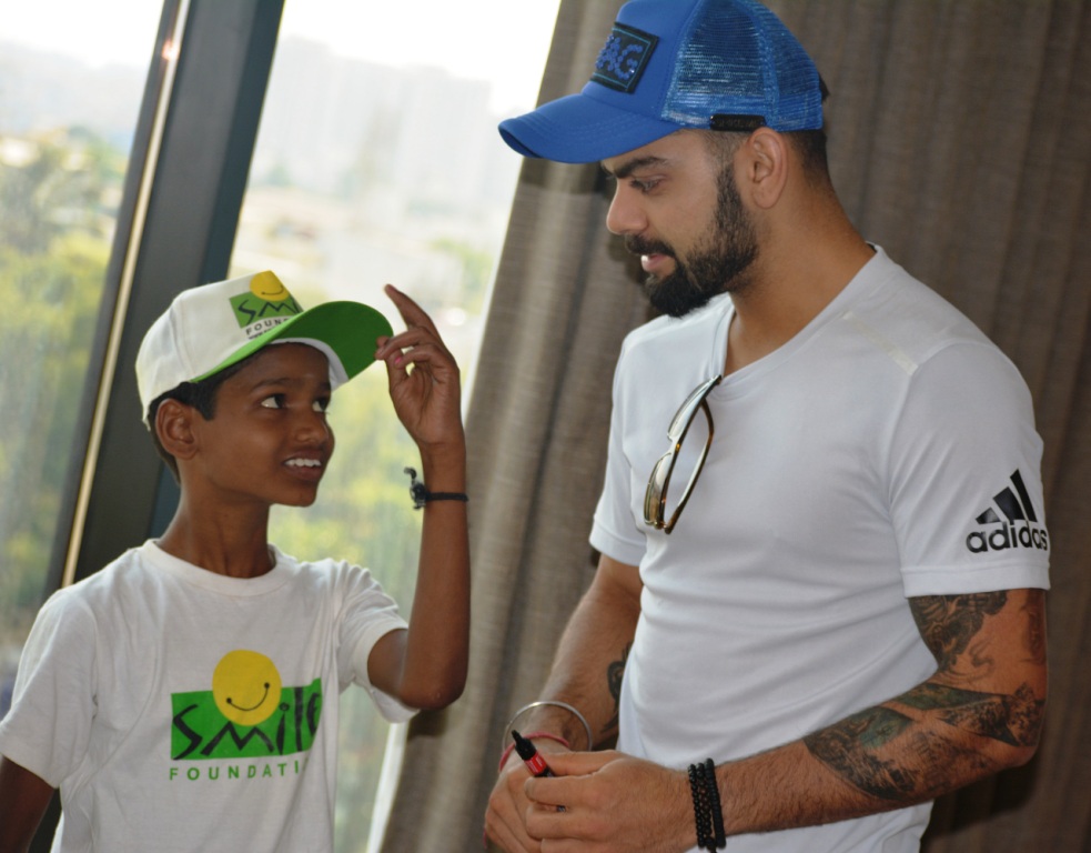 Virat Kohli sharing some batting tips with a Smile Foundation kid